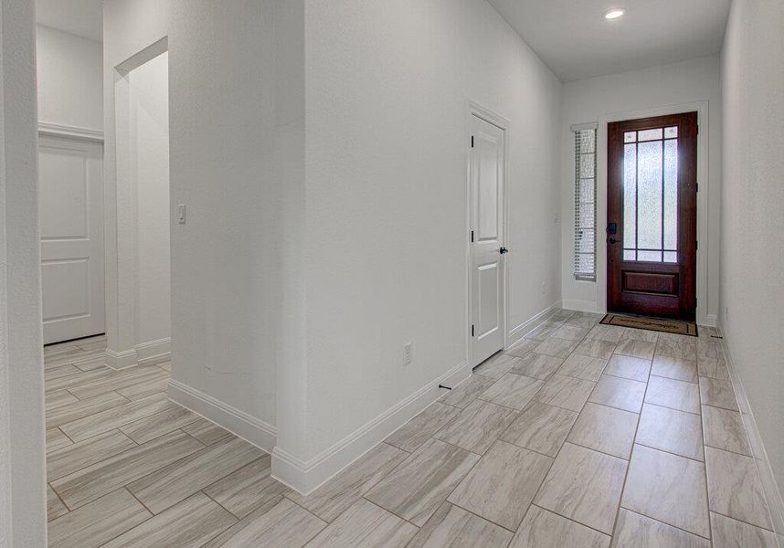 Polished tile floors guide the way through this light-filled entry with high ceilings. Polished tile floors guide the way through this light-filled entry with high ceilings.
