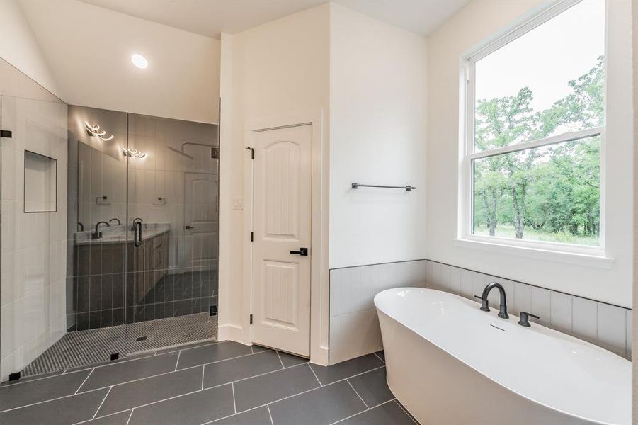 Bathroom featuring a shower stall, a freestanding bath, a wainscoted wall, tile patterned flooring, and recessed lighting