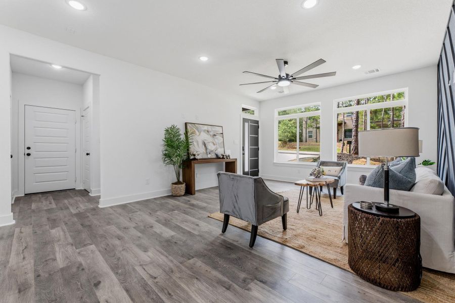 Recessed lighting illuminates this bright living space with durable flooring and generous windows.