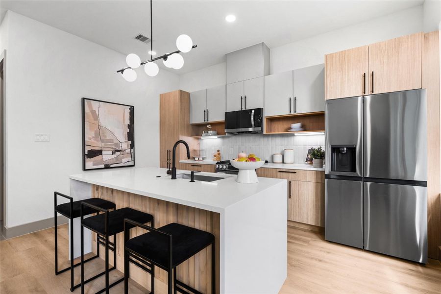 This statement island does it all—prep, serve, sip your morning coffee or gather with friends. Wrapped in a waterfall quartz slab with slatted wood detail and matte black fixtures, it's where everyday routines feel a little more luxurious. This statement island does it all—prep, serve, sip your morning coffee or gather with friends. Wrapped in a waterfall quartz slab with slatted wood detail and matte black fixtures, it's where everyday routines feel a little more luxurious.