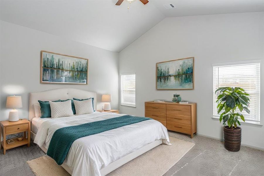 The expansive primary bedroom is a serene sanctuary with vaulted ceilings, large windows for natural light, and soft carpeting underfoot. The open layout offers ample space for a king-sized bed and additional furnishings. A perfect retreat to relax and recharge after a busy day.