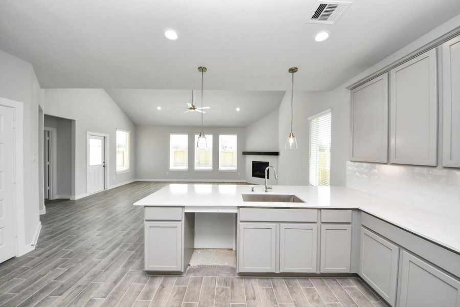 This kitchen is truly a chef's dream! This haven Boasts high ceilings, recessed & pendant lighting, stained wood cabinets, granite countertops, stainless steel appliances, a modern tile backsplash. All of this overlooks your expansive family room, creating a perfect space for culinary delights and family gatherings. Sample photo of completed home with similar floor plan. Actual colors and selections may vary. This kitchen is truly a chef's dream! This haven Boasts high ceilings, recessed & pendant lighting, stained wood cabinets, granite countertops, stainless steel appliances, a modern tile backsplash. All of this overlooks your expansive family room, creating a perfect space for culinary delights and family gatherings. Sample photo of completed home with similar floor plan. Actual colors and selections may vary.