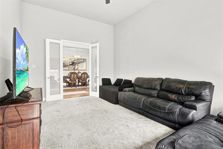 Carpeted living room featuring french doors