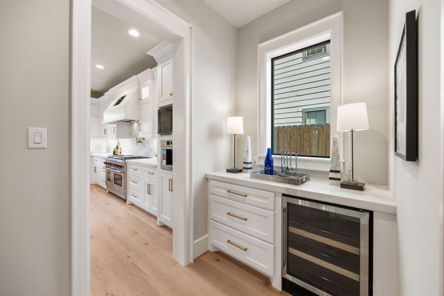 Butler Pantry is equipped w/ beverage fridge, additional pot/pan drawers & window to let in natural light. Walk-in Pantry sits just to the right of it w/ an entrance into the Formal Dining Room.