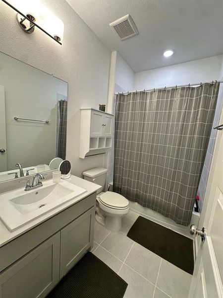 Bathroom with vanity, toilet, tile patterned floors, shower / bath combo with shower curtain, and recessed lighting