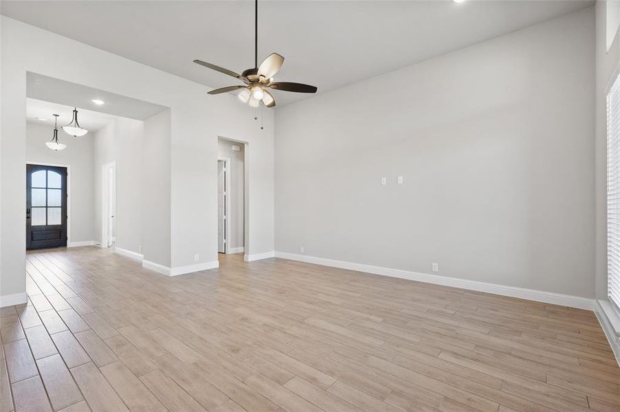 Empty room featuring light wood-style flooring, ceiling fan, and recessed lighting