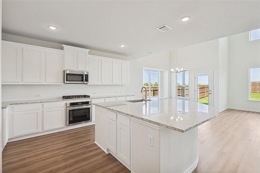 Kitchen featuring light hardwood / wood-style floors, appliances with stainless steel finishes, sink, and white cabinets