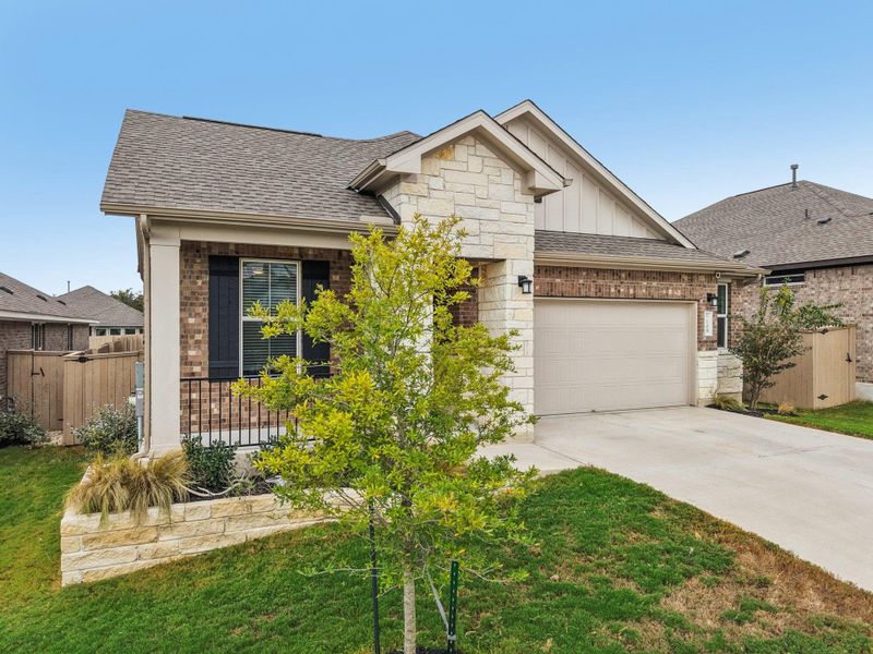 View of front of house featuring board and batten siding, a shingled roof, brick siding, and concrete driveway View of front of house featuring board and batten siding, a shingled roof, brick siding, and concrete driveway