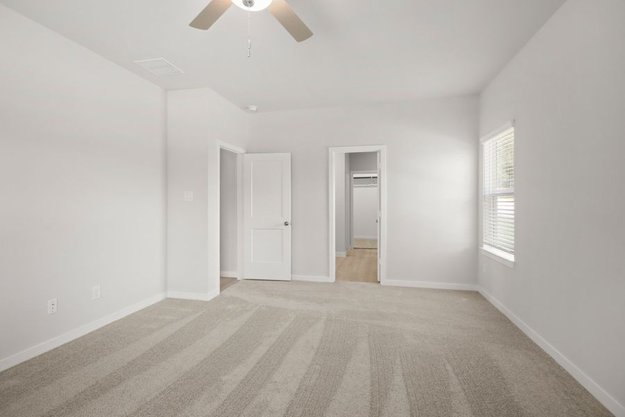 A room with a ceiling fan and a door.