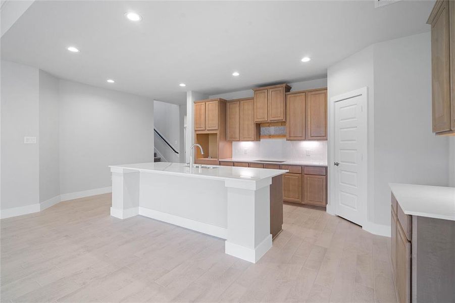 This kitchen is by far any chef’s dream! This spacious kitchen features high ceilings, stained wood cabinets, quartz countertops, SS appliances, modern tile backsplash, recessed lighting, quartz kitchen island with space for breakfast bar and extra storage, and a walk-in pantry all overlooking your huge family room.