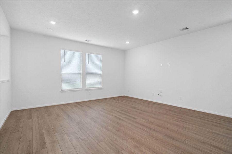 Bring family and friends together in this beautiful Great Room! It features high ceilings, recessed lighting, custom paint, stunning vinyl plank flooring, and large windows that fill the space with natural light all day long.