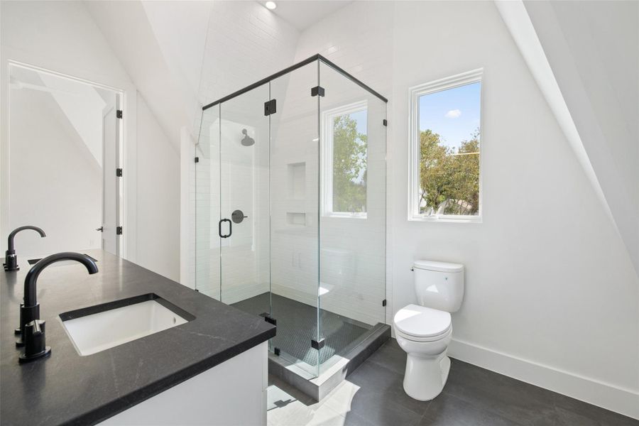 Full bath with double vanity, a shower stall, and recessed lighting