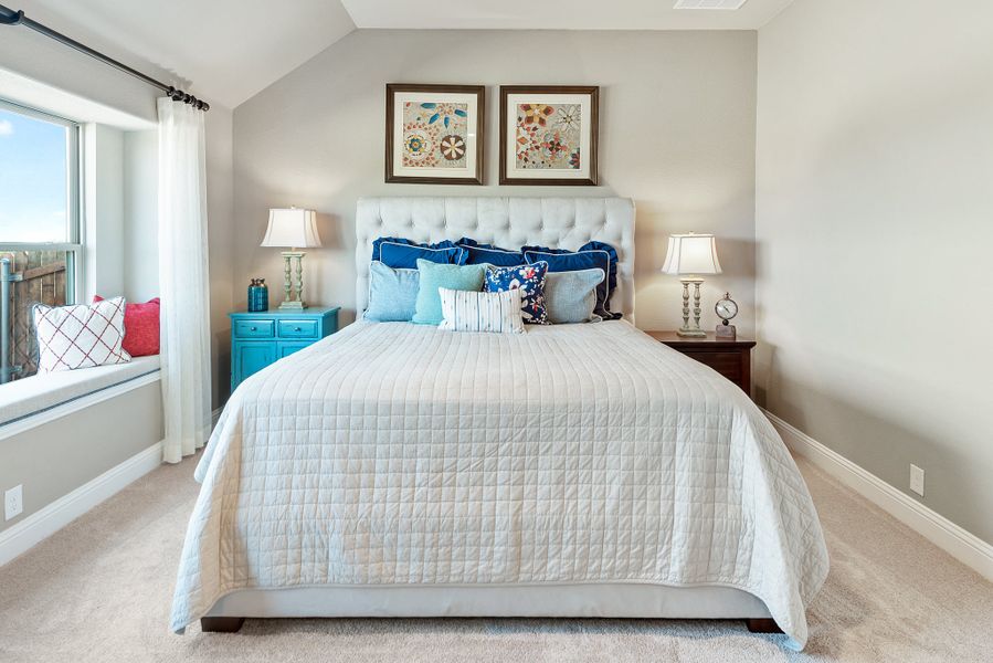 Bedroom with tufted upholstered headboard, white quilt, window seat, and vaulted ceiling Bedroom with tufted upholstered headboard, white quilt, window seat, and vaulted ceiling