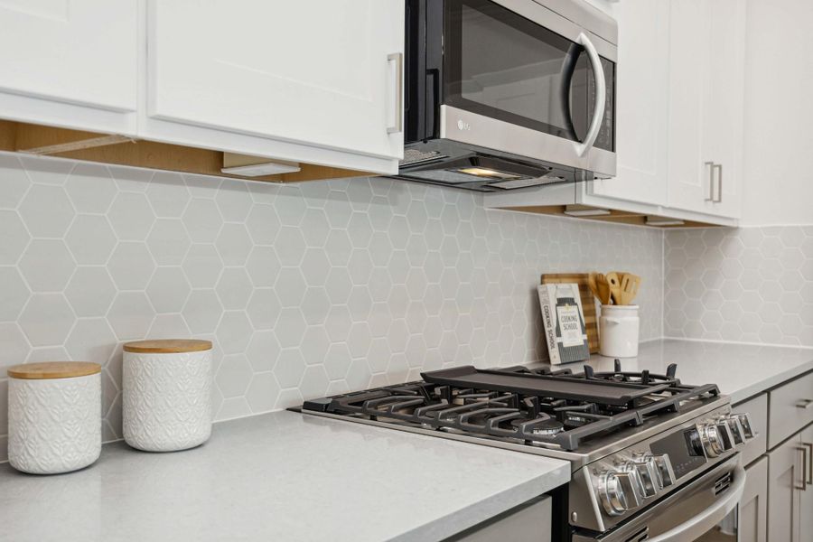 The kind of kitchen details that stop the scroll. Upgraded backsplash, brushed hardware, and custom cabinetry all come together to make this space seriously swoon-worthy. The kind of kitchen details that stop the scroll. Upgraded backsplash, brushed hardware, and custom cabinetry all come together to make this space seriously swoon-worthy.