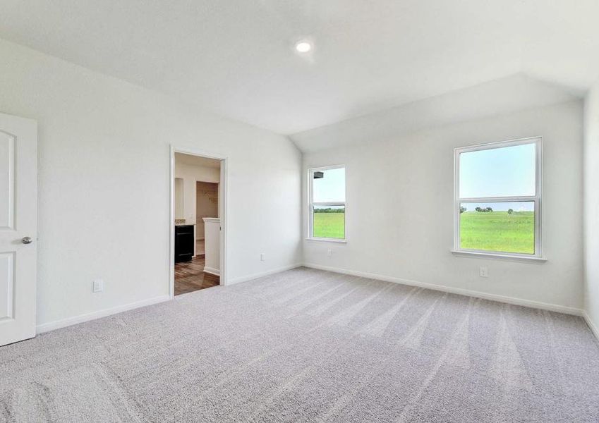 The Rio model home's master bedroom. Entrance to the master bath, two windows looking outside. White walls and window trim, carpet