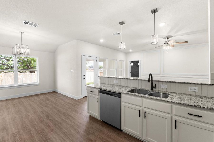 Kitchen with white cabinetry, light stone countertops, stainless steel dishwasher, dark wood-style flooring, and a ceiling fan