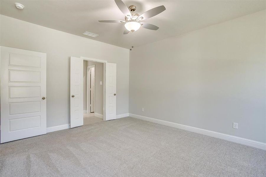 Unfurnished bedroom with light carpet and a ceiling fan Unfurnished bedroom with light carpet and a ceiling fan