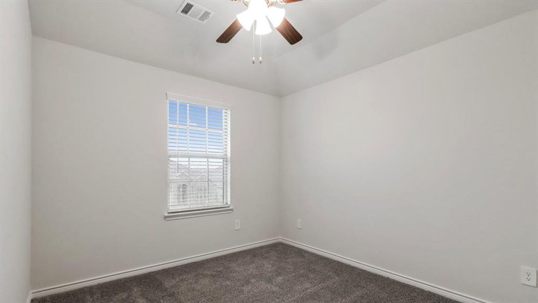 Carpeted empty room featuring a ceiling fan and vaulted ceiling Carpeted empty room featuring a ceiling fan and vaulted ceiling