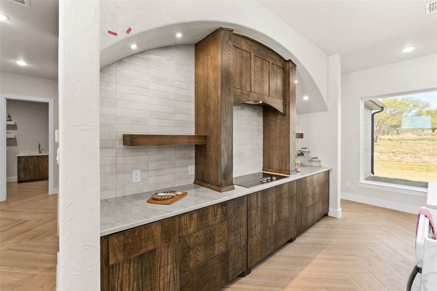 Kitchen with recessed lighting, backsplash, dark brown cabinets, open shelves, and modern cabinets