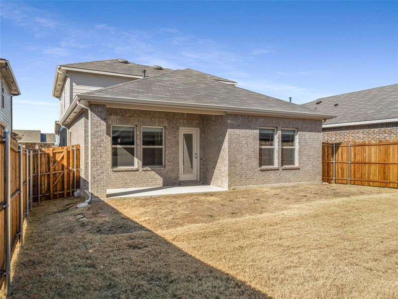 Rear view of house featuring a patio and a lawn