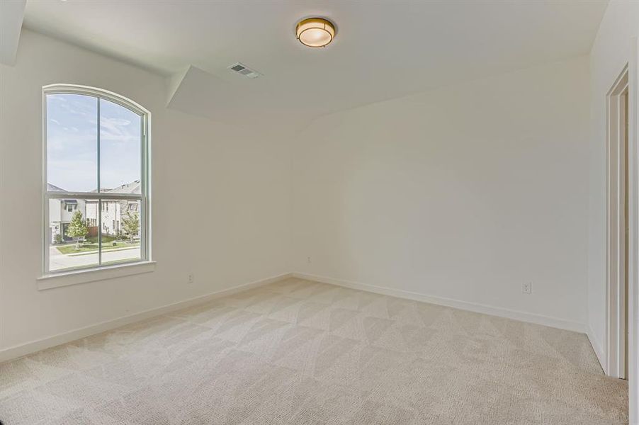 Empty room with light colored carpet and baseboards
