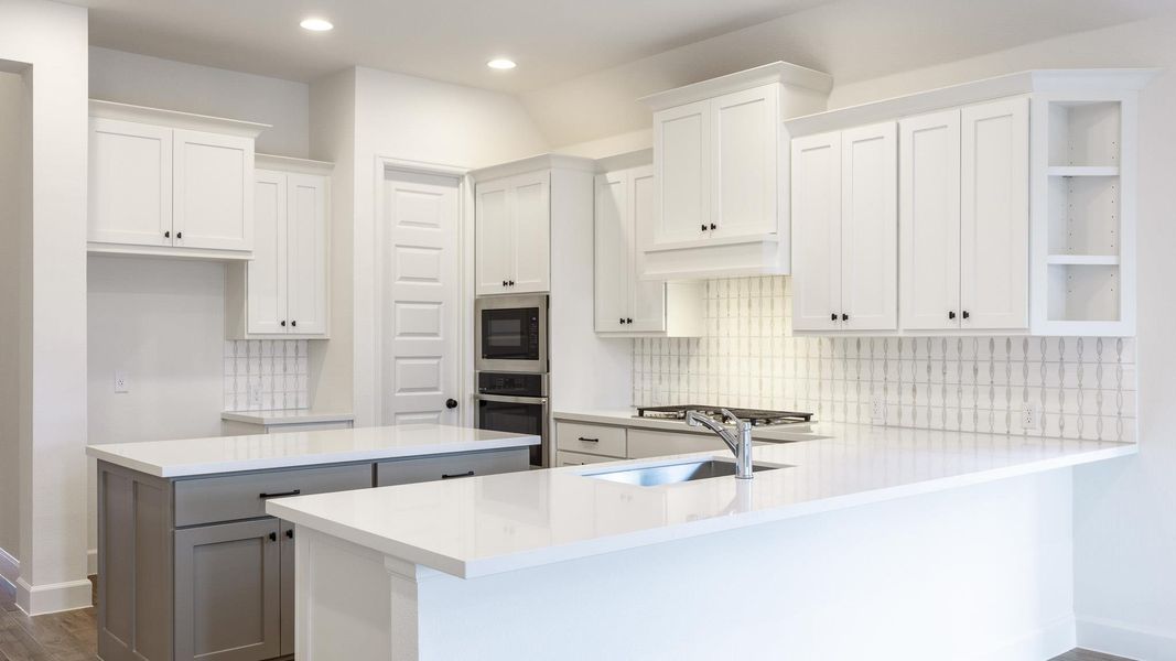 Kitchen featuring a kitchen island, backsplash, a peninsula, oven, and recessed lighting Kitchen featuring a kitchen island, backsplash, a peninsula, oven, and recessed lighting