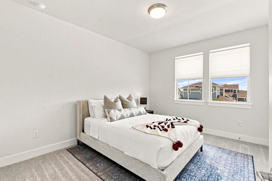 Secondary upstairs bedroom featuring bright windows, plush carpet, and generous closet space. Secondary upstairs bedroom featuring bright windows, plush carpet, and generous closet space.