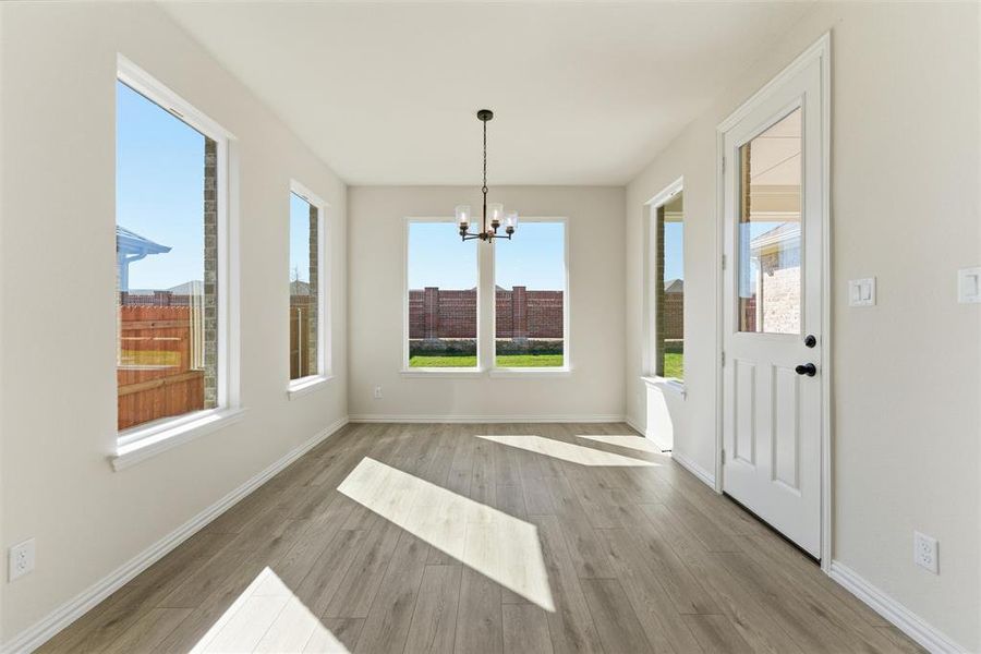 Unfurnished dining area with a chandelier and light wood-style flooring