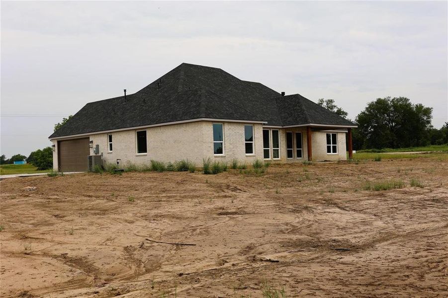 Rear view of property featuring central AC