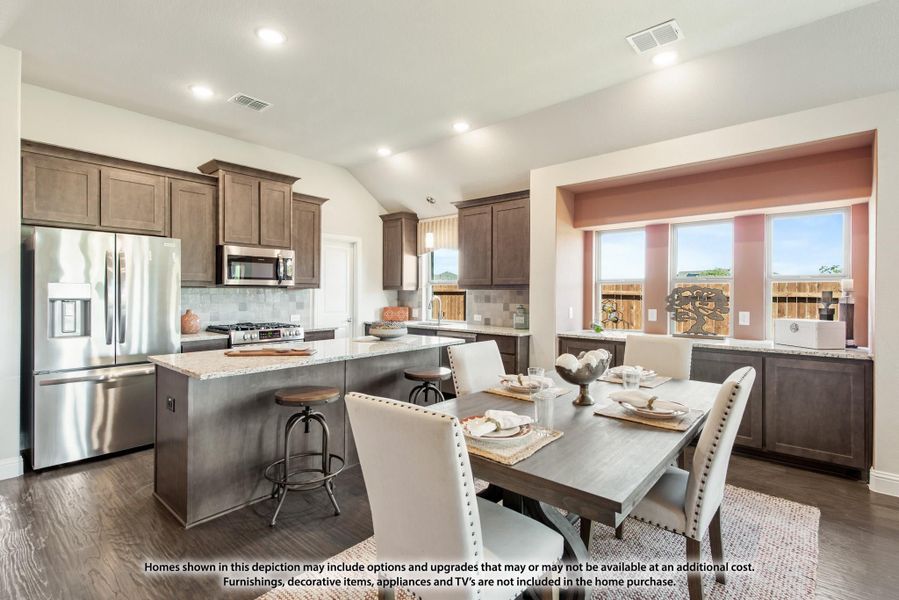 Open kitchen and dining area with dark wood cabinets, granite island, stainless appliances, and dining table near bay window Open kitchen and dining area with dark wood cabinets, granite island, stainless appliances, and dining table near bay window