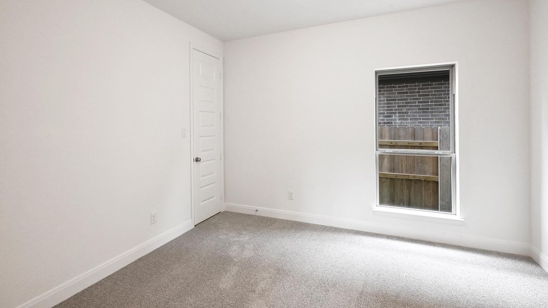 Carpeted empty room featuring baseboards