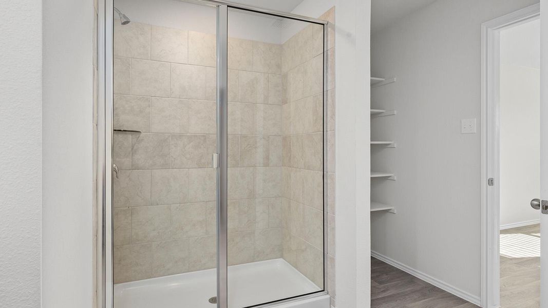 Full bathroom featuring a shower stall and light wood-style flooring