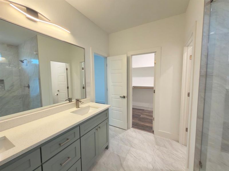 Bathroom featuring a double vanity with light gray cabinetry and light-toned countertops