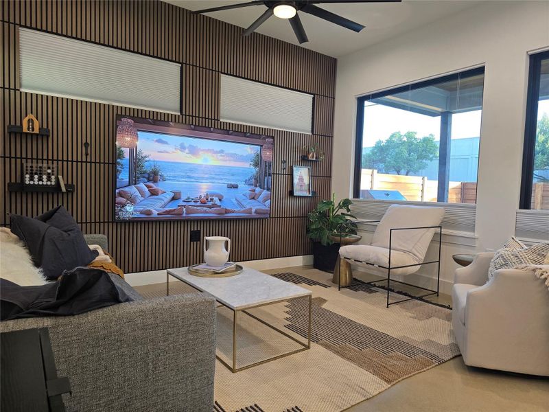 Floor-to-ceiling windows and a custom wood slat wall define this modern living space.