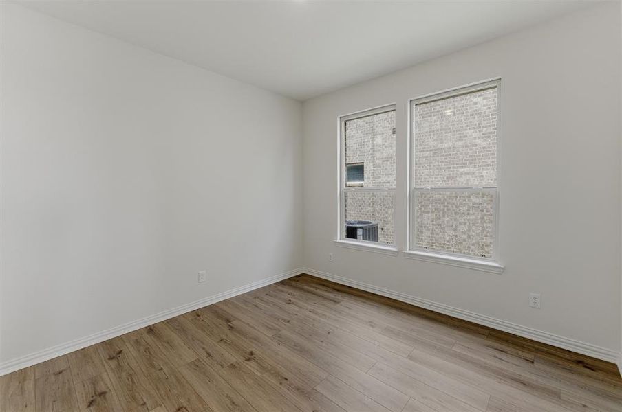 Spacious room featuring wood-finish flooring and dual windows