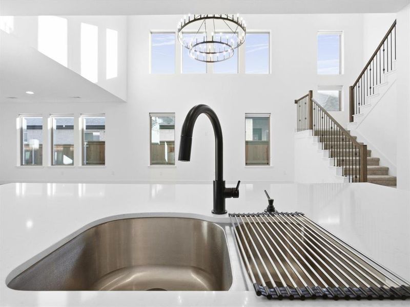 Kitchen view of a sink and light stone counters Kitchen view of a sink and light stone counters