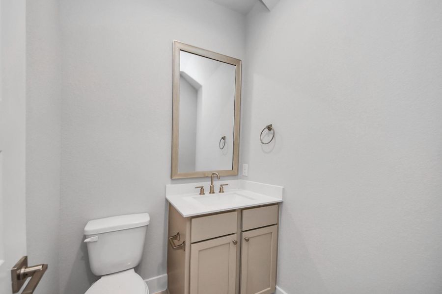 Sophisticated half bathroom adorned with contemporary finishes. The elegant 5-panel door welcomes you to a space where style meets functionality. Notice the sleek hardware accents that add a touch of modern charm. The vanity boasts light-colored countertops, beautifully complemented by a tasteful vanity light, creating a well-lit and inviting atmosphere. Sophisticated half bathroom adorned with contemporary finishes. The elegant 5-panel door welcomes you to a space where style meets functionality. Notice the sleek hardware accents that add a touch of modern charm. The vanity boasts light-colored countertops, beautifully complemented by a tasteful vanity light, creating a well-lit and inviting atmosphere.
