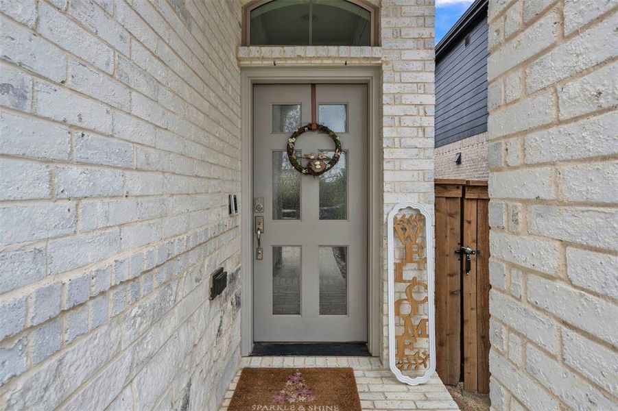 Front entry featuring a light gray paneled door with glass inserts and an arched transom window Front entry featuring a light gray paneled door with glass inserts and an arched transom window