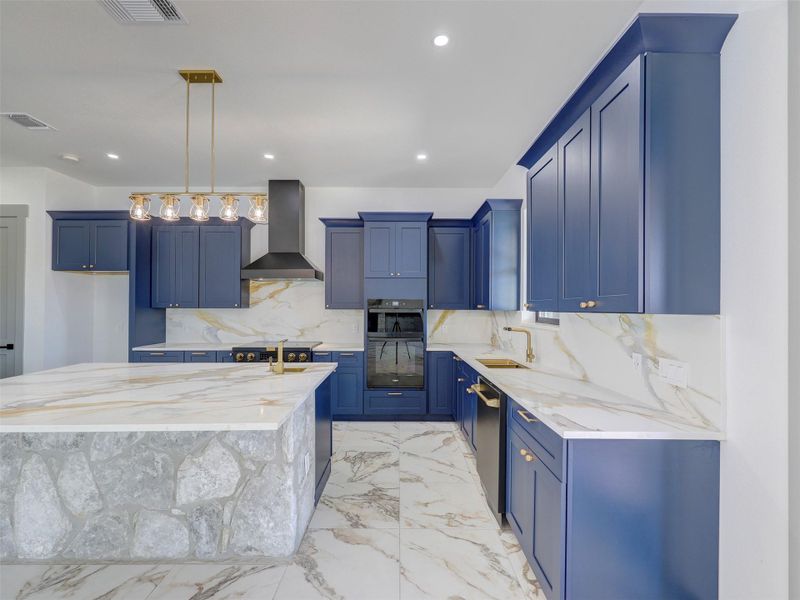 Richly veined marble flooring and stone details anchor this modern kitchen with custom cabinetry.