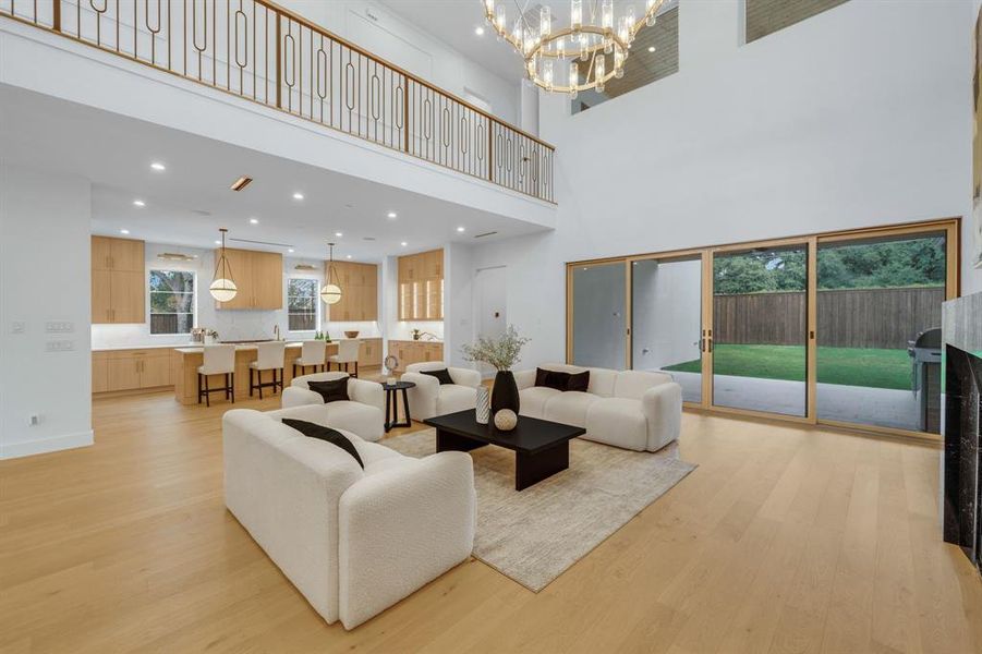 Living area with light wood-style floors, a chandelier, recessed lighting, and a fireplace