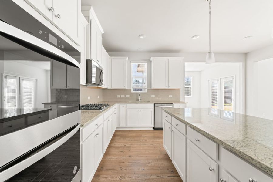 A kitchen with white cabinets.