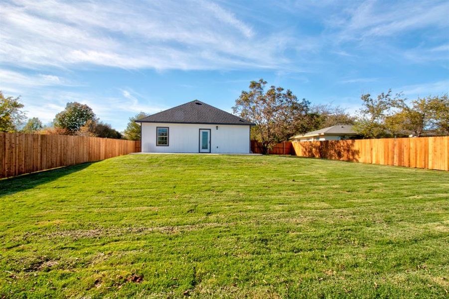 Back of house with a yard