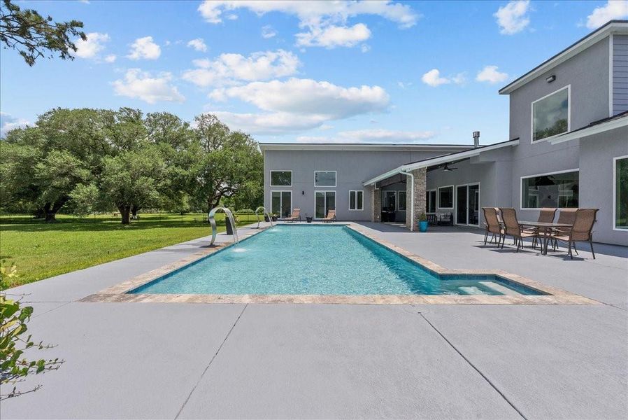 The expansive deck is perfect for sunbathing while looking out over the lush green yard.
