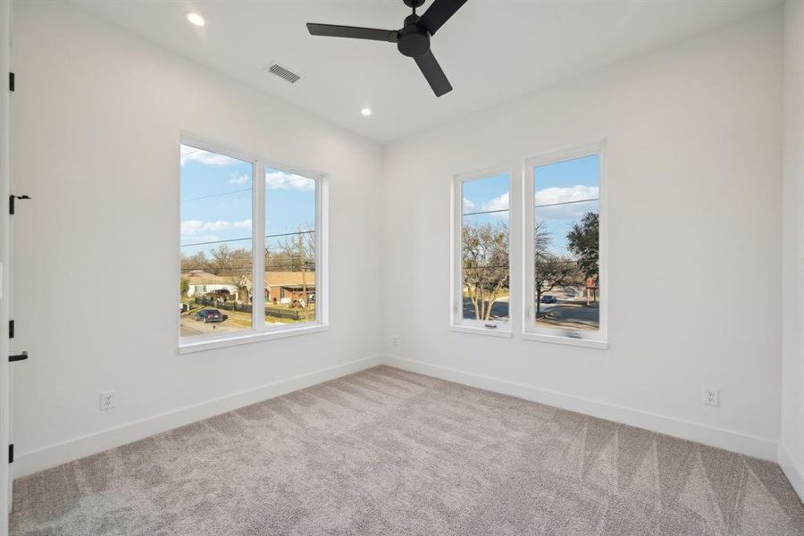 Carpeted spare room featuring ceiling fan