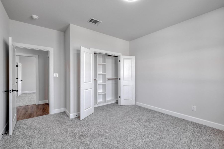 Unfurnished bedroom featuring carpet flooring, baseboards, and a closet