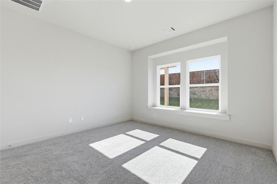 Carpeted room featuring a large window, neutral wall paint, white trim, and recessed lighting
