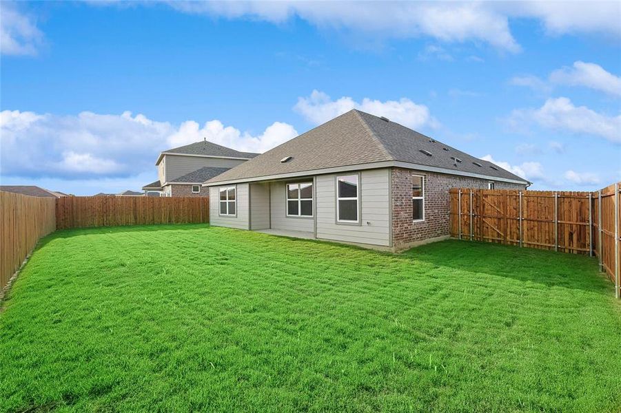 Rear view of property with a lawn