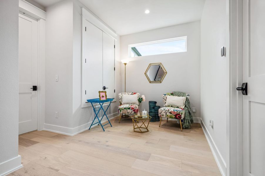 Sitting room with light wood-style floors and recessed lighting