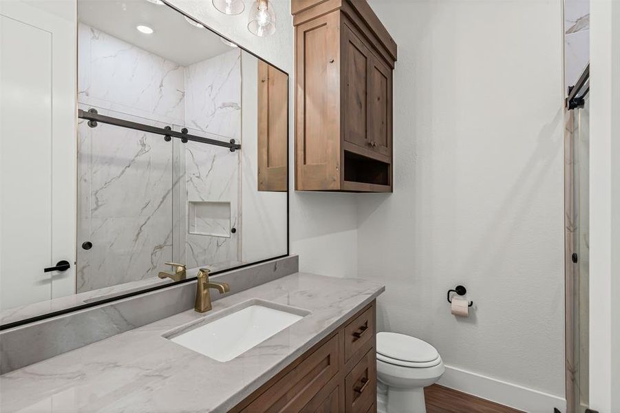 Full bath with vanity, dark wood-style floors, and a marble finish shower Full bath with vanity, dark wood-style floors, and a marble finish shower