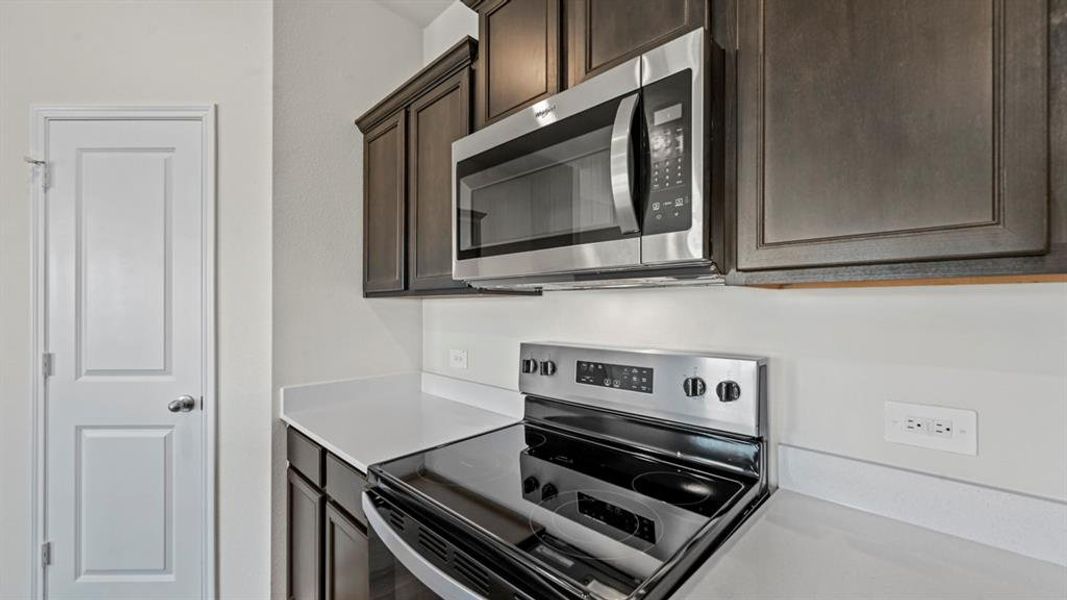 Stainless steel range and microwave oven with dark wood-finish cabinetry